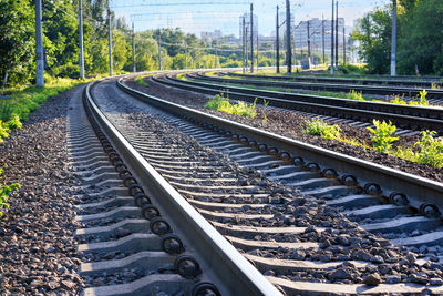 A multi-lane railway stretching into the distance with a turn towards city buildings on the horizon.