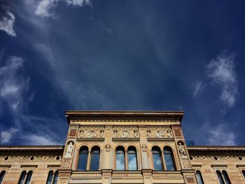 Low angle view of building against cloudy sky