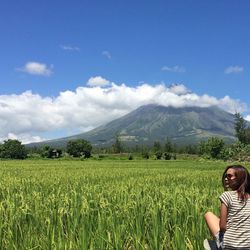 Woman on green field against sky