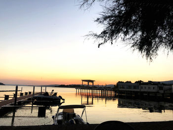 Silhouette boats in marina at sunset