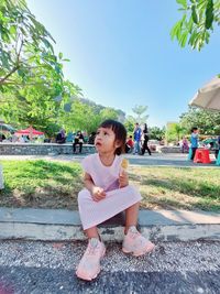 Girl is sitting in the garden while eating