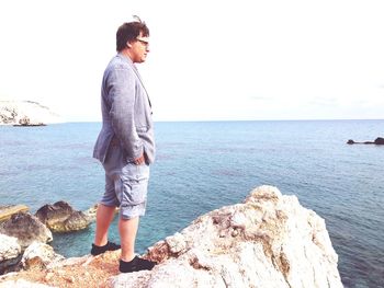 Full length of young man looking at sea against sky