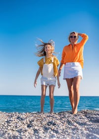 Full length of young woman standing at beach