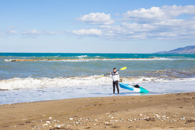 Men standing on beach against sky