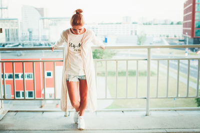 Full length of woman standing against railing