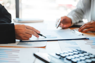 Cropped image of people working on table