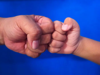 Close-up of hands against blue background