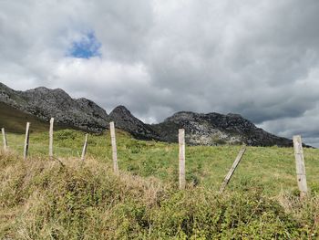 Wooden fence on field against sky