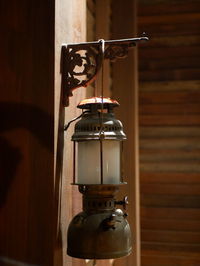 Close-up of electric lamp on table against wall