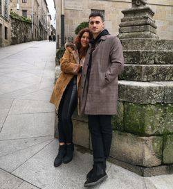 Full length portrait of smiling couple in city during winter
