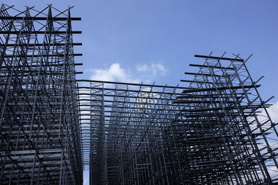Low angle view of metallic construction frame against sky