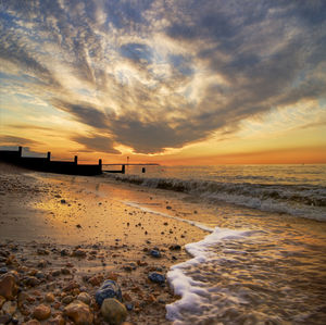 Scenic view of beach against sky during sunset