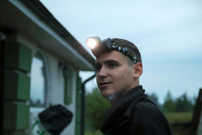 Low angle view of young woman standing against building