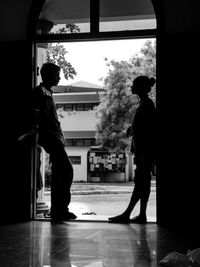 Side view of silhouette man standing by window in building