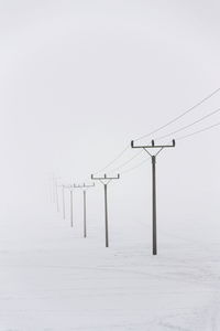 Wind turbine against clear sky during winter