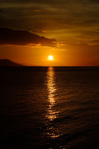 Scenic view of sea against dramatic sky during sunset