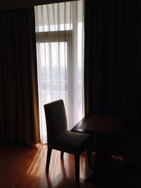 Empty chair against curtain at home