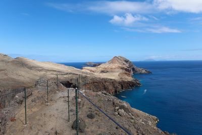 Scenic view of sea and mountains against blue sky