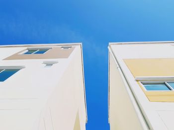 Low angle view of buildings against clear blue sky