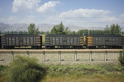 Train by railroad tracks against sky