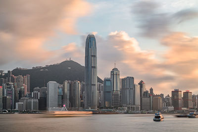 Modern buildings in city against sky during sunset