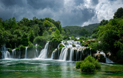 Scenic view of waterfall against sky