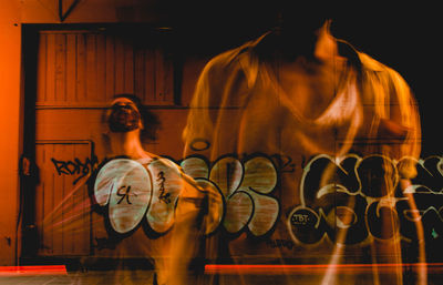 Rear view of man standing against orange wall