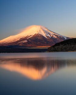 Scenic view of snowcapped fuji mountain against sky during sunrise