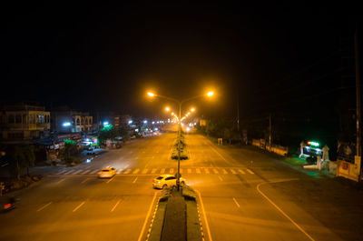 Light trails on road in city against clear sky at night
