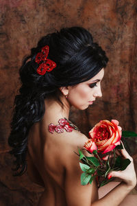 Close-up of woman with red rose