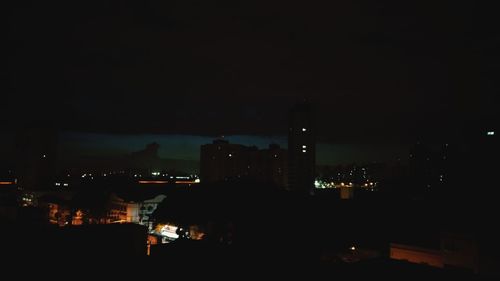 Illuminated cityscape against sky at night