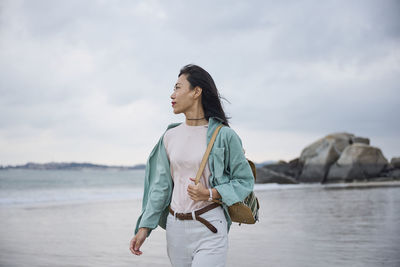 Beautiful asian girl walking on the beach in autumn during her trip