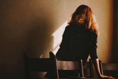 Rear view of woman sitting on table