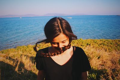 Beautiful young woman against sea