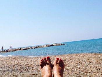 Low section of woman standing on beach