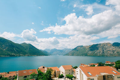 Scenic view of sea by houses and mountains against sky