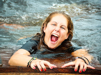 Portrait of mid adult woman swimming screaming in lake