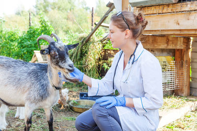 Side view of man with goat