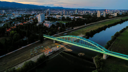High angle view of illuminated bridge over river in city at night