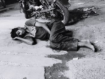 Full length of man sleeping on road