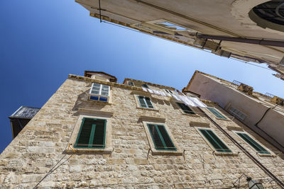 Low angle view of old building against blue sky