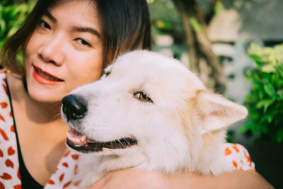 Close-up portrait of smiling woman holding dog