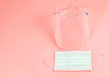 Close-up of electric light on table against pink background