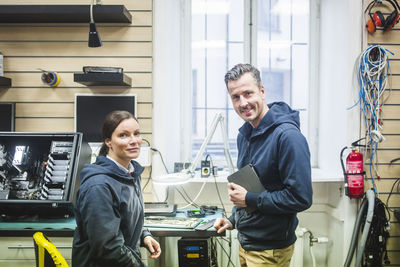 Portrait of confident smiling computer engineers working in electronics store