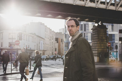 Portrait of serious man wearing jacket standing in city