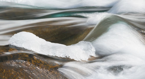 Extreme close-up of water flowing through snow