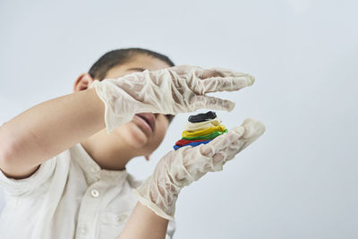 Midsection of child holding hands against white background