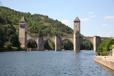 Arch bridge over river against building