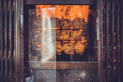 Meat hanging over barbecue grill