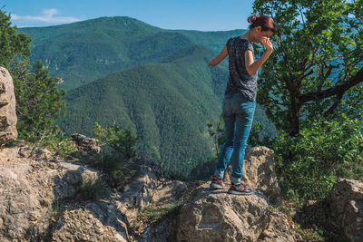 Young woman on mountain against trees